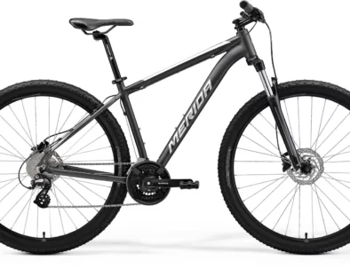Black Merida mountain bike with thick tires, disc brakes, and a sleek frame.