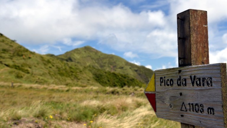 Wooden sign for Pico da Vara with mountain and grass in background.