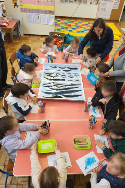 Children in classroom sitting around table with fish samples.