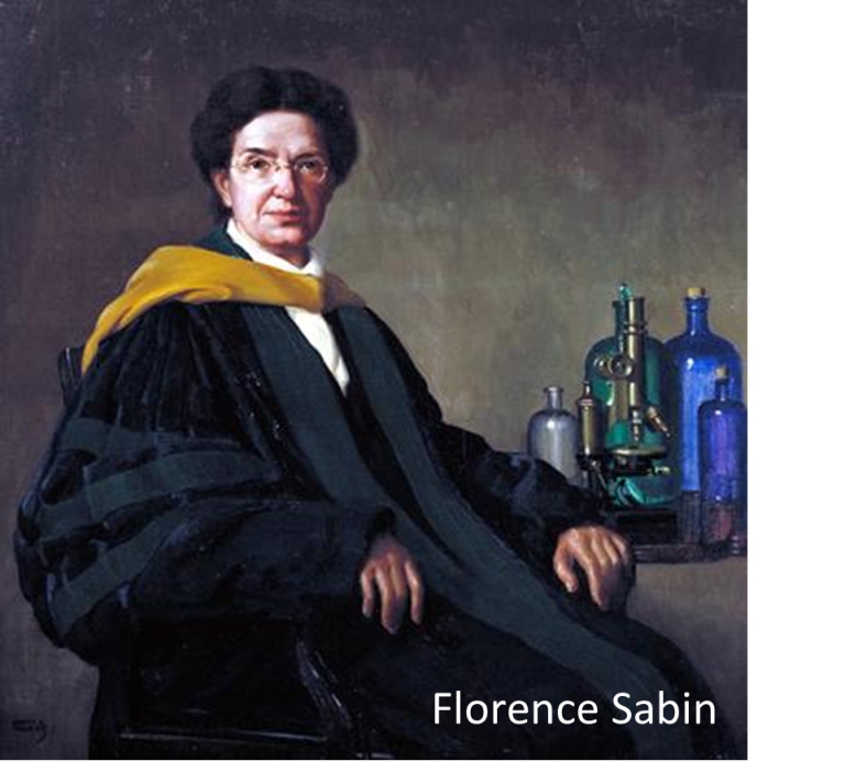 A person in academic robes with scientific instruments on a table.