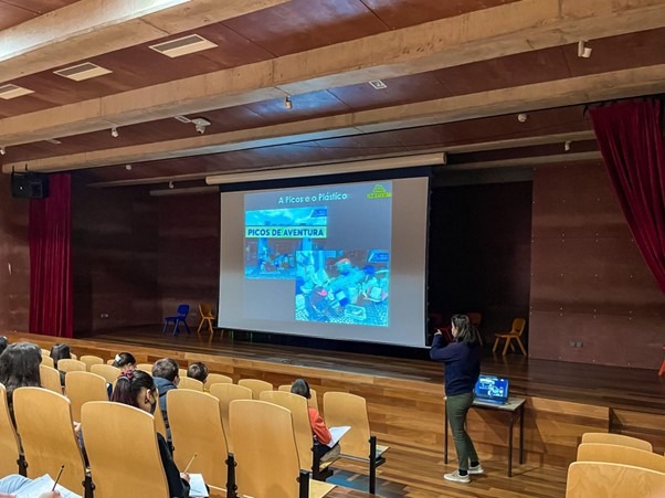 Lecture hall with a presentation on screen and an audience seated.