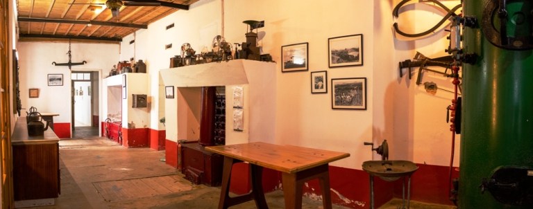 Vintage room with wooden table, framed photos, and antique equipment on display.