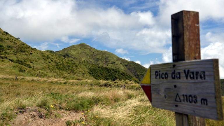 Mountain landscape with a wooden sign reading 'Pico da Vara 1103 m.'