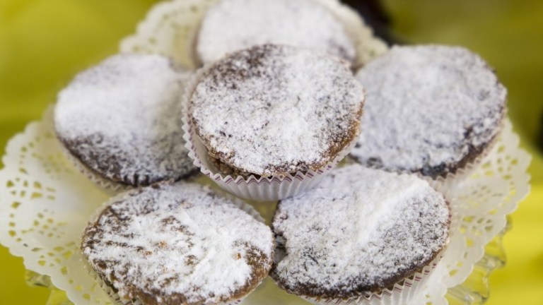 Powdered muffins on a lace-patterned plate.